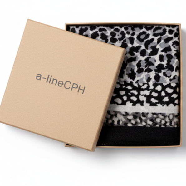 Close-up of soft black wool cashmere fabric with leopard print texture and package